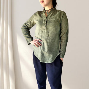 amber-buttoned-Vneck-blouse-with-button-tab-long-sleeves-in-khaki-closeup-view-with-adem-and-eve-casual-pants