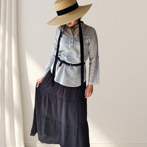 amber-buttoned-Vneck-blouse-with-rolled-up-button-tab-long-sleeves-in-stone-worn-with-belt-and-dahlia-maxi-skirt-in-black-front-view