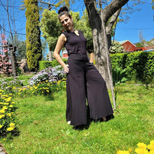 Load image into Gallery viewer, cotton-palazzo-pants-with-extra-wide-leg-fitted-mid-waist-elasticated-at-back-and-side-pockets-in-black-front-of-tree-side-view-2
