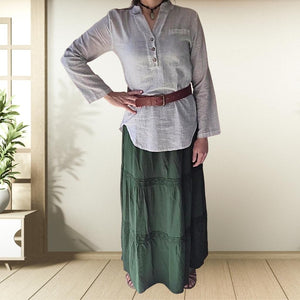 dahlia-tiered-maxi-skirt-with-lace-trim-in-green-worn-with-V-neck-blouse-in-stone-and-brown-wide-belt-and-leather-sandals-front-view