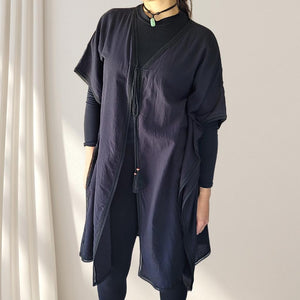 cotton-kimono-tunic-with-V-neckline-short-batwing-sleeves-and-straight-hemline-with-lace-edging-and-front-string-tie-with-tassel-trim-in-black-worn-with-black-tights-and-top-front-view