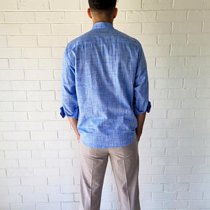 long-sleeve-shirt-with-band-collar-button-up-front-single-chest-pocket-in-speckled-blue-worn-with-chino-pants-in-light-grey-back-view