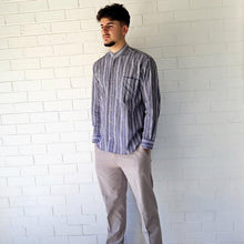 Load image into Gallery viewer, long-sleeve-shirt-with-band-collar-button-up-front-and-single-chest-pocket-in-striped-grey-worn-with-chino-pants-in-light-grey-front-view
