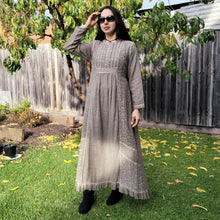 Load image into Gallery viewer, long-sleeve-cotton-maxi-dress-in-mocha-with-eyelet-embroidery-on-front-sides-pintuck-detail-on-chest-lace-frill-at-skirt-hem-and-string-tie-at-waist-back
