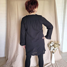 Load image into Gallery viewer, selena-long-sleeve-tunic-with-round-string-tie-neck-embroidery-on-chest-panel-and-lace-detail-and-ruffles-on-the-sleeve-ends-and-hemline-in-black-black-view
