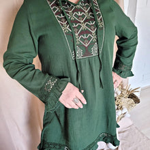 Load image into Gallery viewer, selena-long-sleeve-tunic-with-round-string-tie-neck-embroidery-on-chest-panel-and-lace-detail-and-ruffles-on-the-sleeve-ends-and-hemline-in-green-close-up-view
