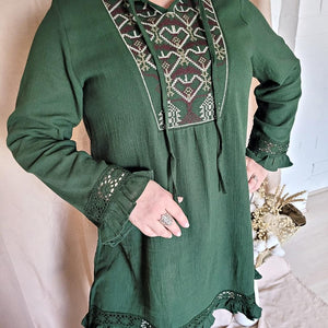 selena-long-sleeve-tunic-with-round-string-tie-neck-embroidery-on-chest-panel-and-lace-detail-and-ruffles-on-the-sleeve-ends-and-hemline-in-green-close-up-view