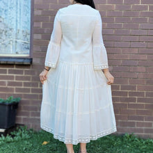 Load image into Gallery viewer, Sharon_tiered_midi_dress_in_cream_with_Vneckline_fitted_buttoned_bust_tiered_skirt_with_lace_trim_at_hem_and_bell_sleeves_with_lace_trim_back_view
