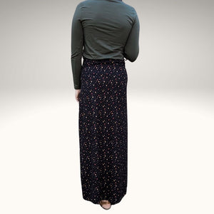 back-view-of-high-waisted-brushed-cotton-flannel-maxi-skirt-in-black-with-ditsy-floral-print-accent-pocket-on-front-right-in-solid-black-and-button-through-off-centre-front-slit