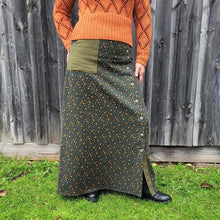 Load image into Gallery viewer, high-waisted-brushed-cotton-flannel-maxi-skirt-in-khaki-with-ditsy-floral-print-accent-pocket-on-front-right-in-solid-khaki-and-button-through-off-centre-front-slit-front-view
