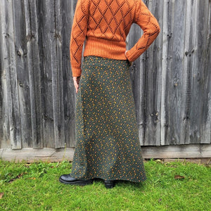 back-view-of-high-waisted-brushed-cotton-flannel-maxi-skirt-in-khaki-with-ditsy-floral-print-accent-pocket-on-front-right-in-solid-khaki-and-button-through-off-centre-front-slit